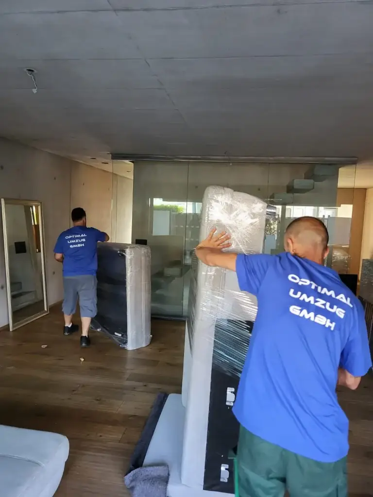 Mitarbeiter von Optimal Umzug verpackt Möbel transportsicher
