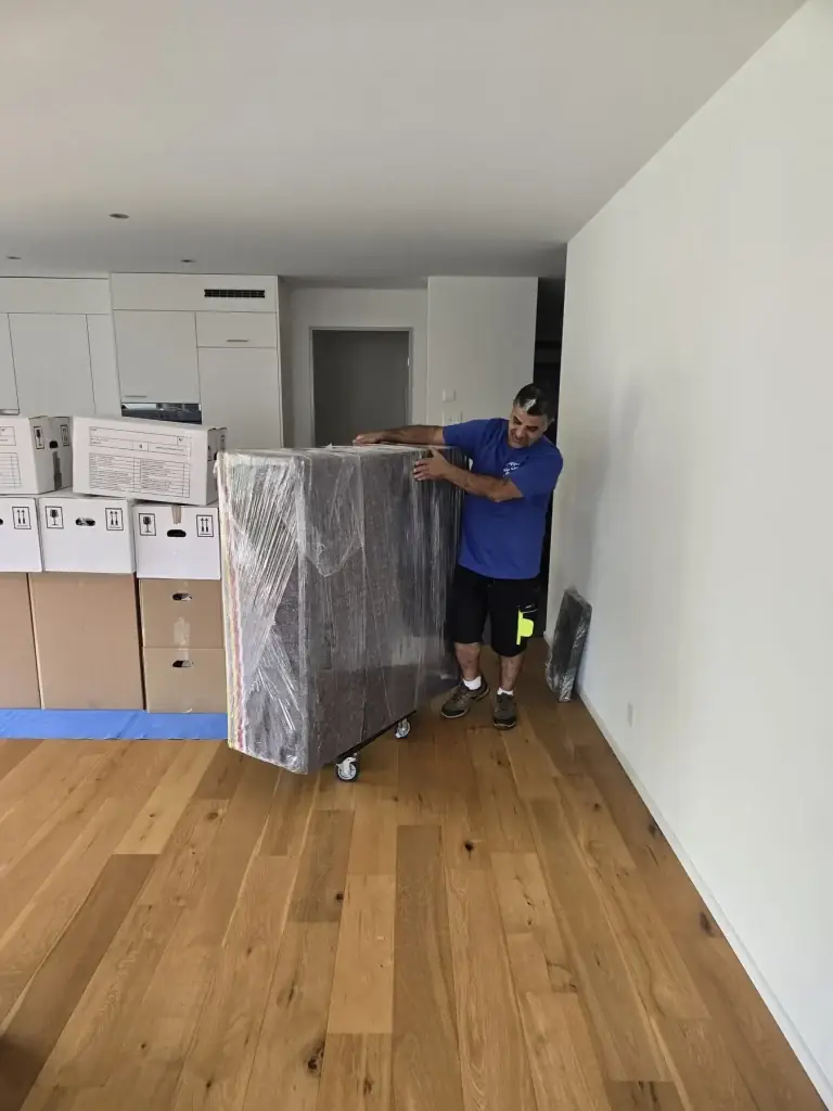 Eingepackter Schrank auf dem Rollbrett in der leeren Wohnung